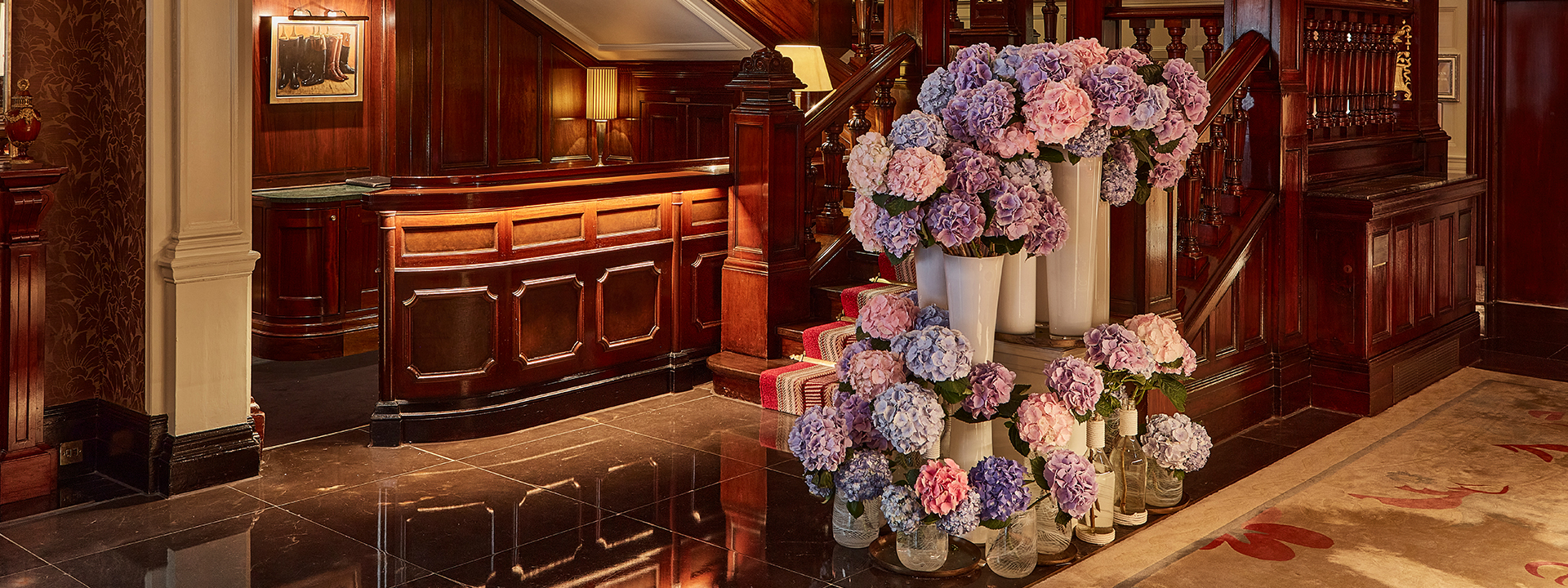 Moyses Stevens Flowers at The Connaught - view of flowers at the bottom of the stairs in the hotel lobby