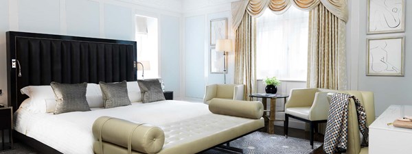 Library Suite at The Connaught - bedroom view with bed, side table and armchairs.