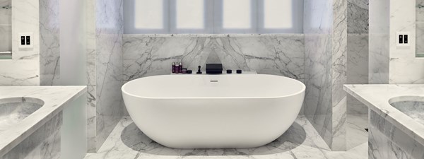 The Mews at The Connaught - bathroom with large bathtub and marble on the floor and on the walls.